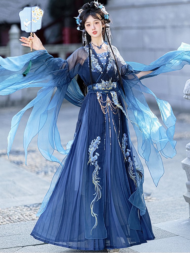 Model posing in motion wearing blue dragon Hanfu with wide sleeves.