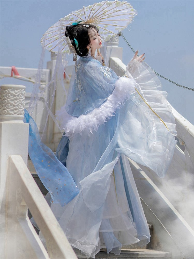 Side pose showcasing sleeve movement and cape overlay