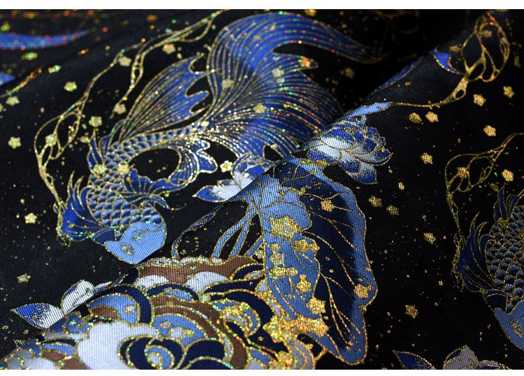 Close-up of gold-thread galaxy embroidery on blue fabric