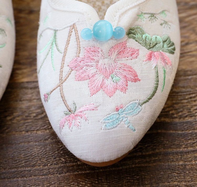 Close-up of floral embroidery on Mary Jane pumps