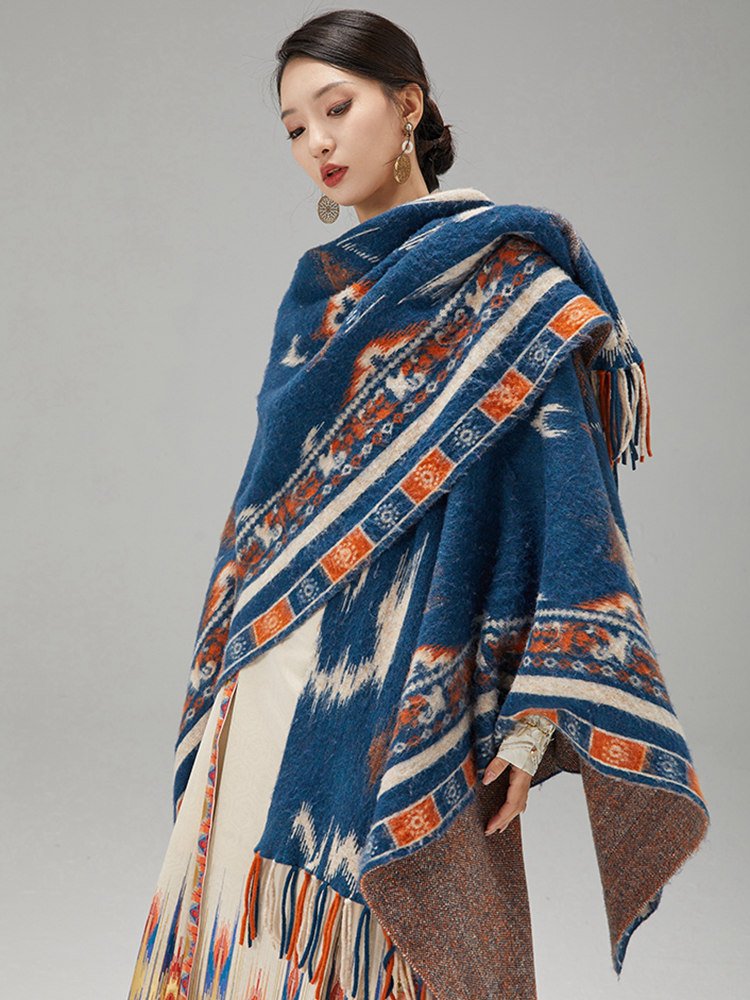 Model wrapping a blue ikat-pattern wool shawl around shoulders over the Mamian skirt.