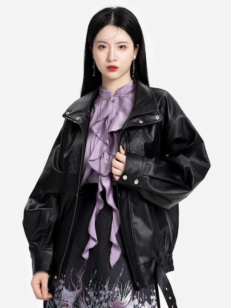 Model wearing lilac stand-collar blouse under black leather jacket with short embroidered skirt.
