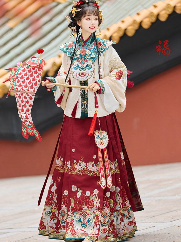 Model in white embroidered jacket with red brocade skirt