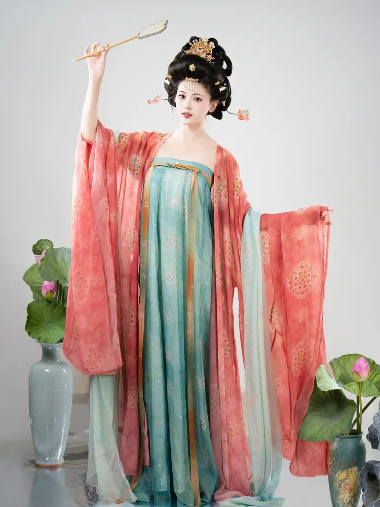 Model standing with peach-red Tang-style shawl draped down naturally beside lotus flowers.