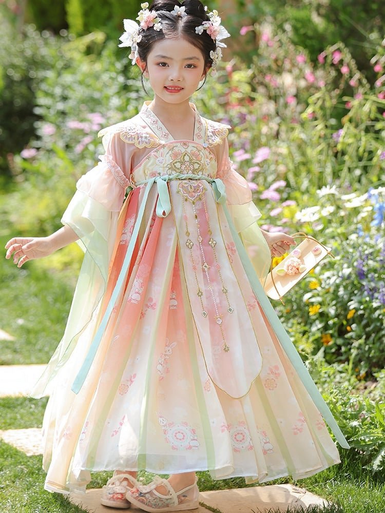 Girl twirling outdoors in a pastel pink and green Hanfu dress