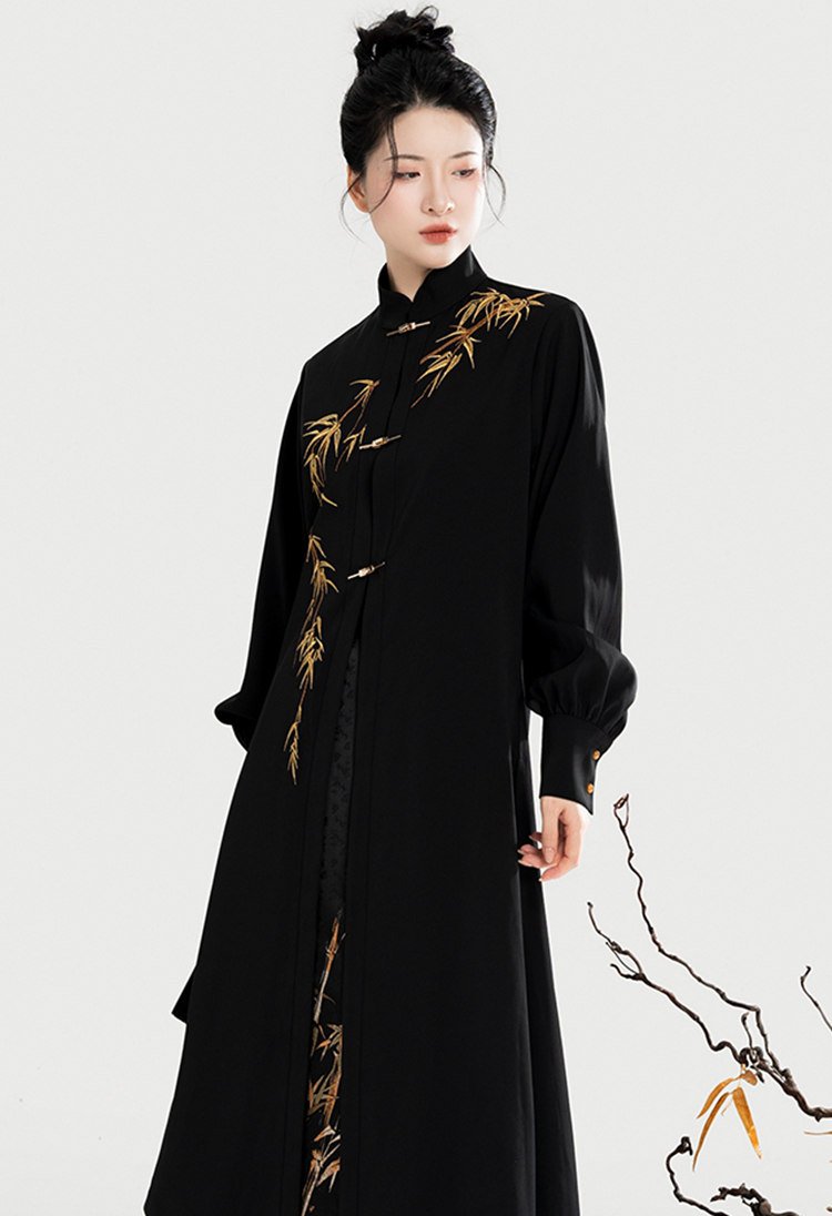 Half-body view of the black stand-collar coat with golden bamboo embroidery.