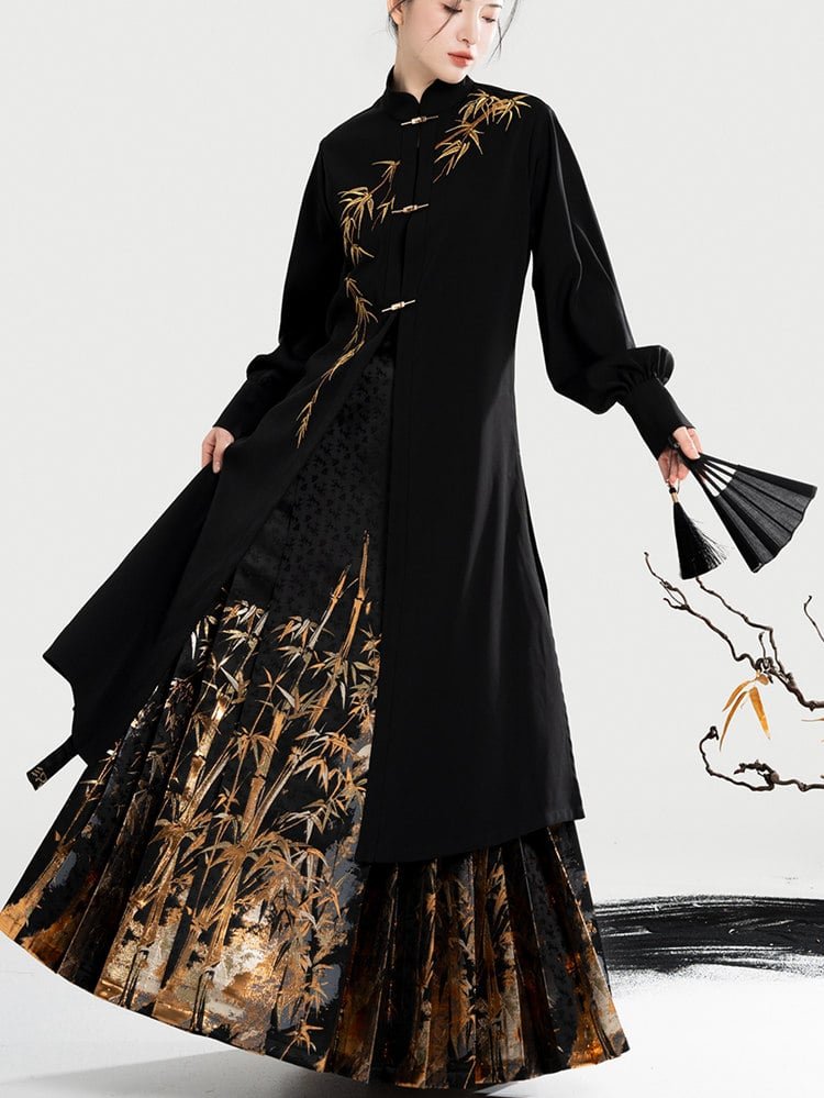 Model walking in black coat and gold bamboo mamian skirt.
