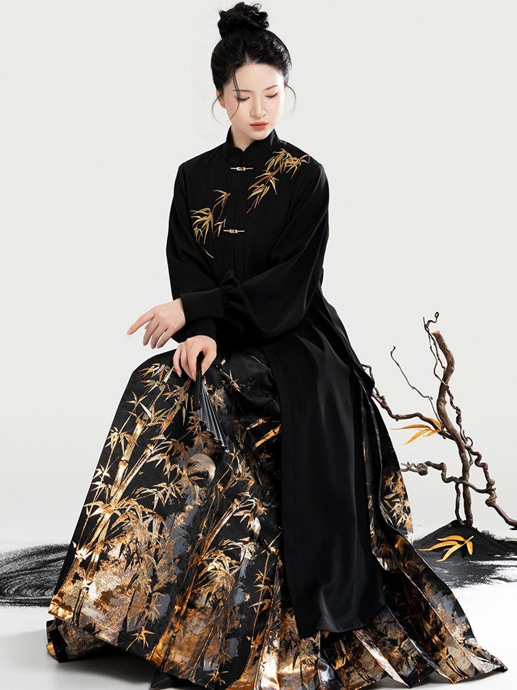 Model sitting with brocade mamian skirt spread out, showing gold bamboo patterns.