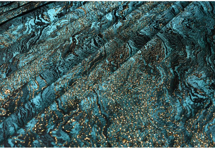Close-up of pleated emerald metallic skirt surface