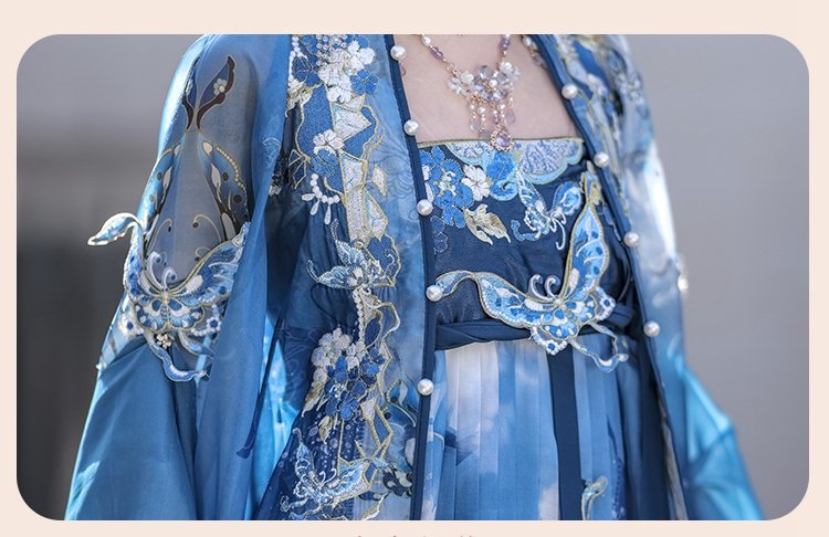 Close-up of butterfly embroidery and beaded embellishments on blue Hanfu dress.