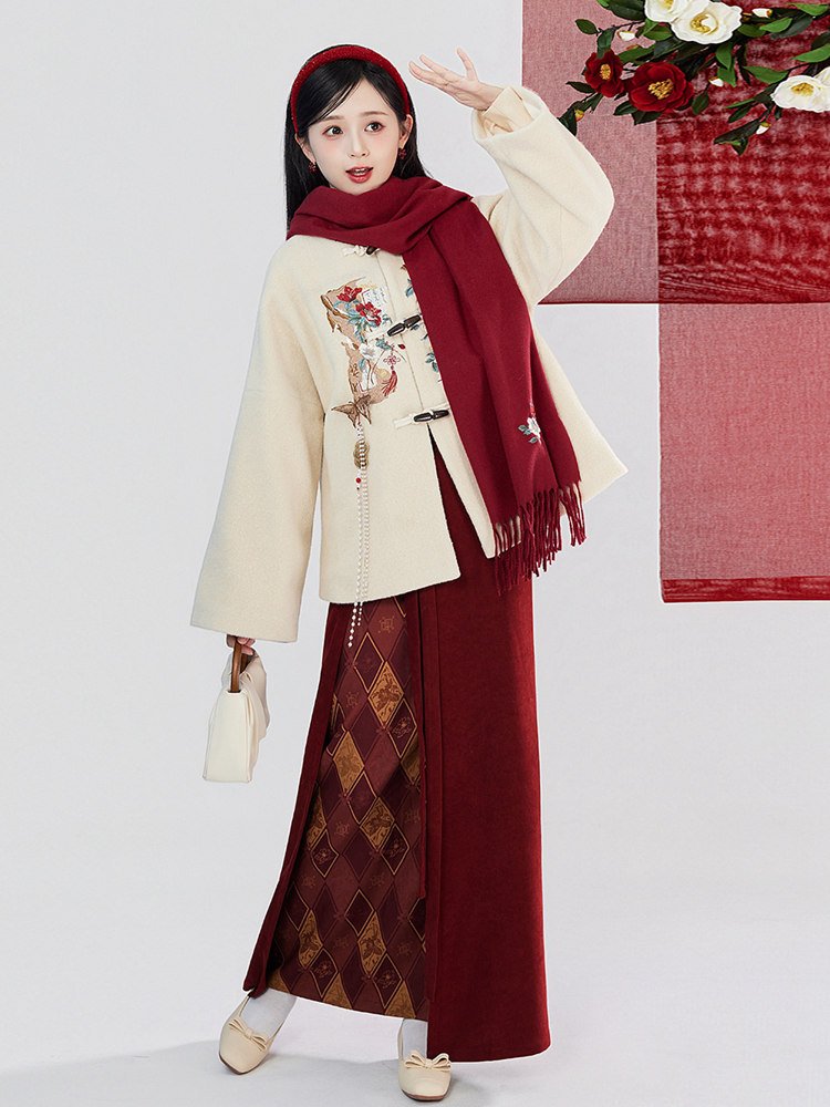 Woman wearing hanfu-inspired New Year outfit with embroidered coat, red wrap skirt, and scarf