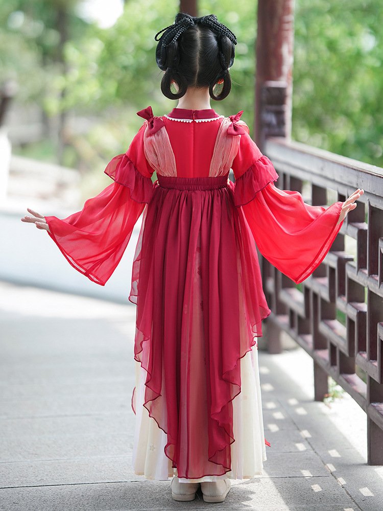 A young girl showing the back of a red Chinese Hanfu dress with flowing sleeves