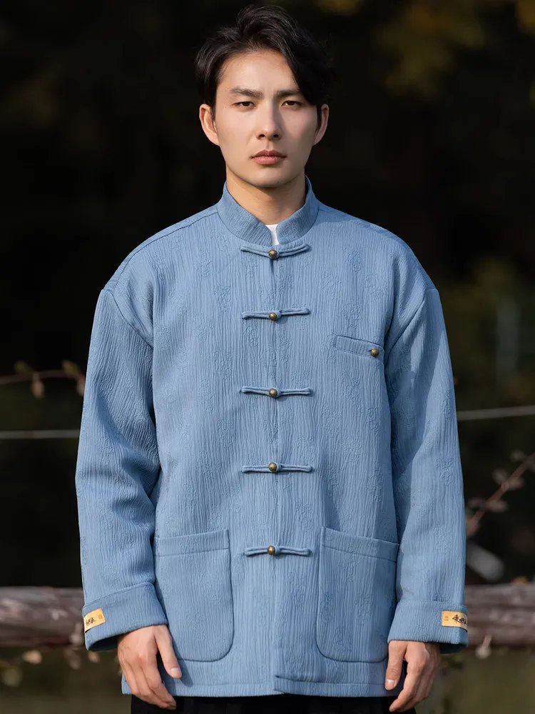 Model wearing a light blue men’s Chinese Tang jacket with a mandarin collar and frog buttons, front upper-body view.