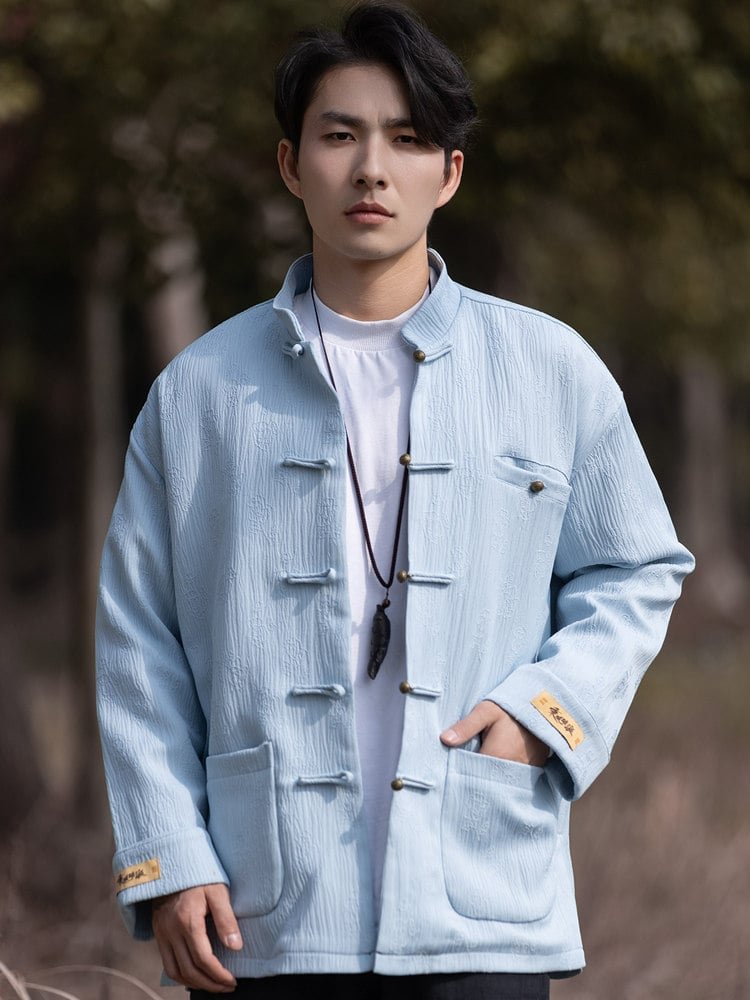 Model wearing a light blue Tang jacket with frog buttons and front pockets, hands casually in pockets.