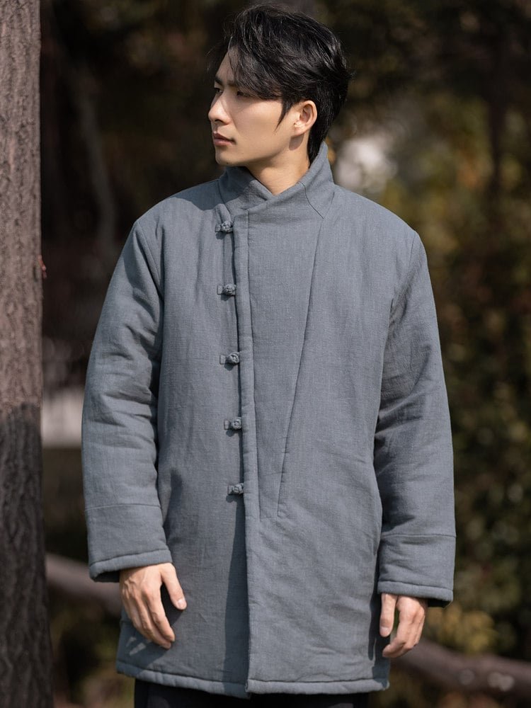Full-body view of a man wearing a gray padded Chinese winter Tang jacket with frog buttons.