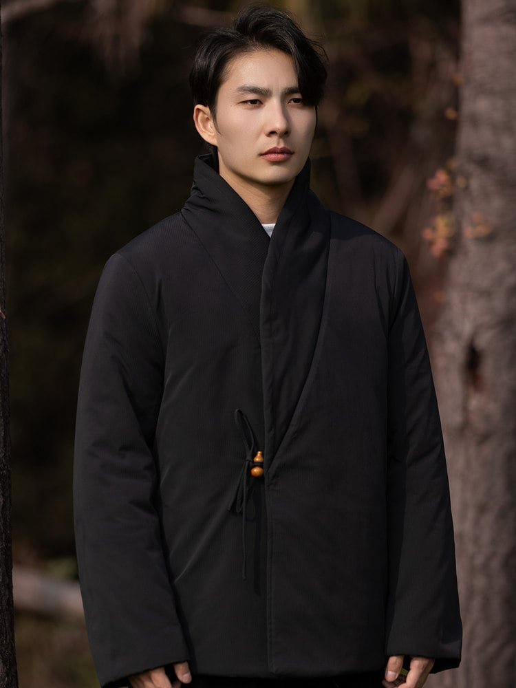 Full-body front view of a man wearing a black Chinese wrap winter jacket.