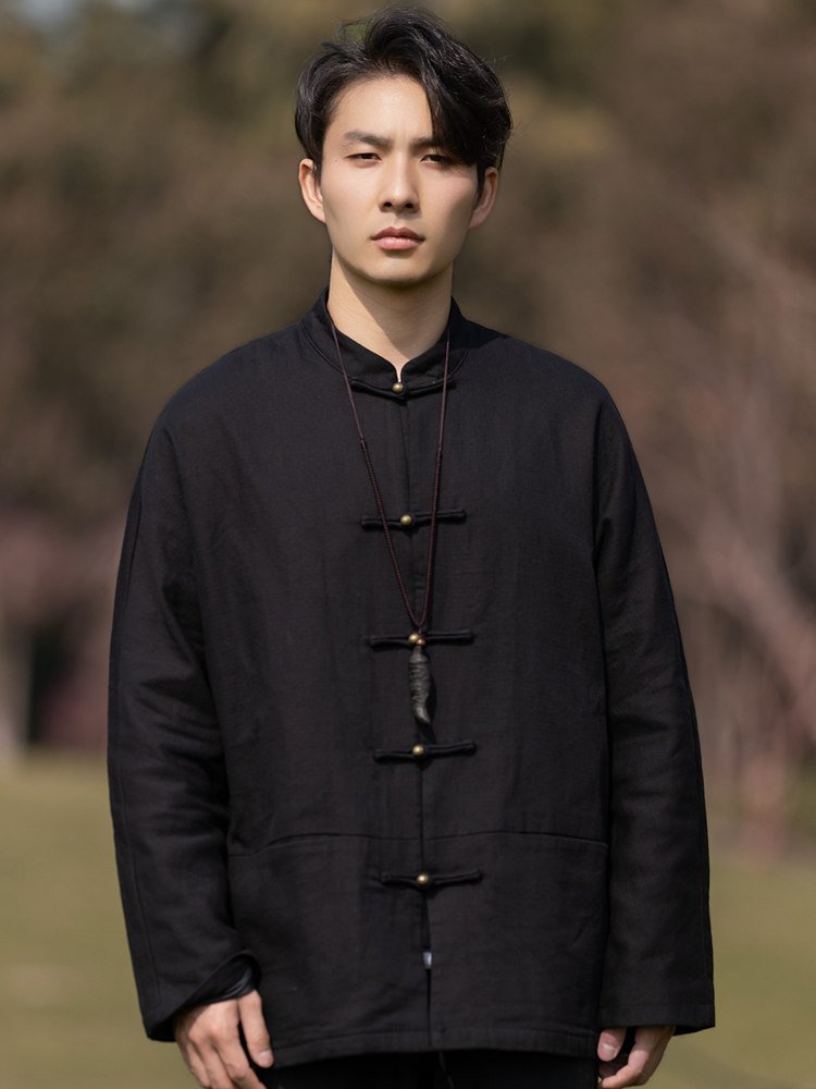 Model wearing a black solid color Chinese Tang jacket with frog buttons and mandarin collar, front upper-body view.