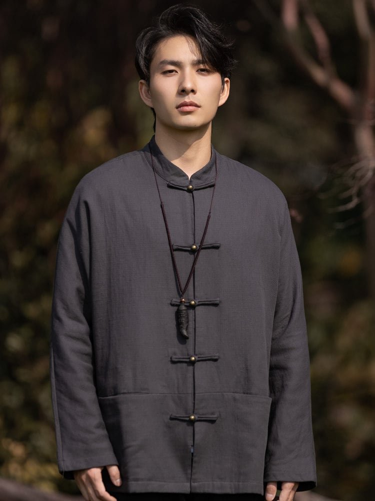 Model wearing a gray solid color Chinese Tang jacket with frog buttons, front upper-body view.