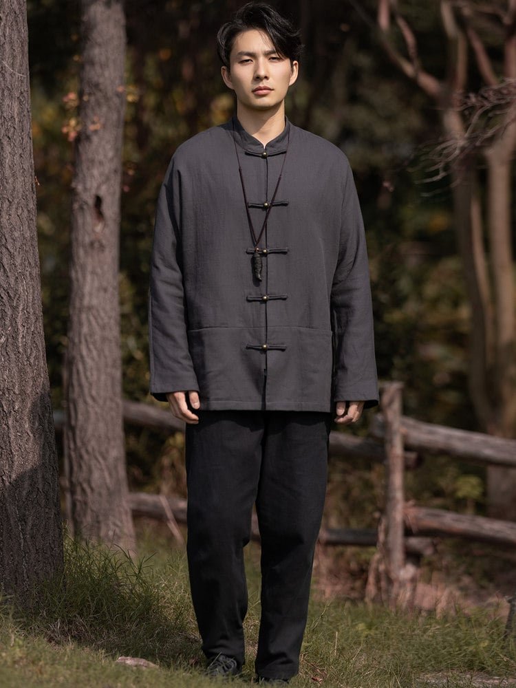 Full-body outdoor view of a man wearing a gray solid color Chinese Tang jacket.