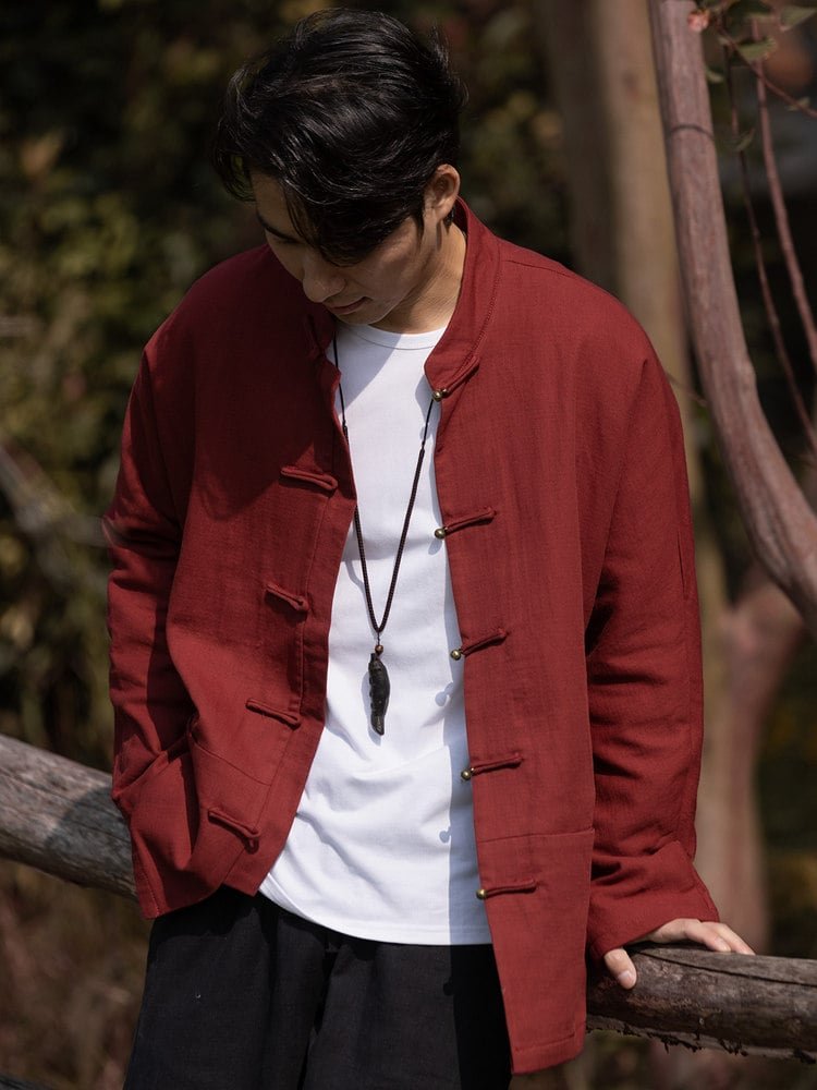 Side-front view of a red men’s solid color Chinese Tang jacket with frog buttons and a mandarin collar.