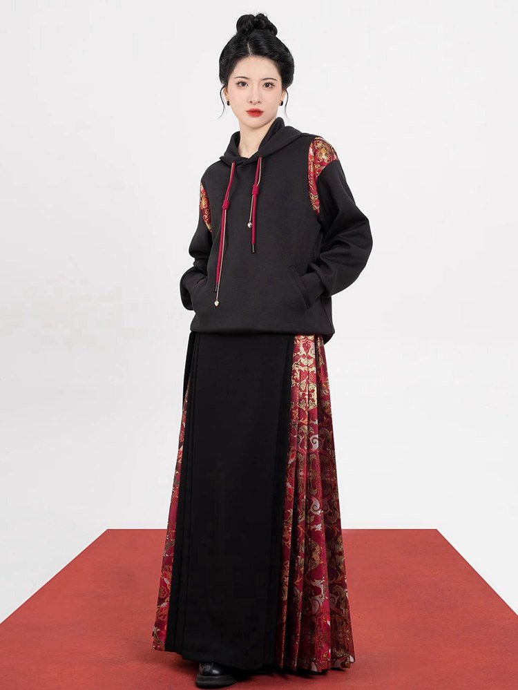 Model styling black skirt with red brocade contrast panels