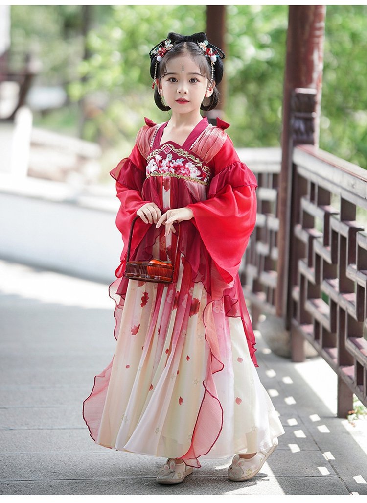 Young girl spinning outdoors in traditional red Hanfu
