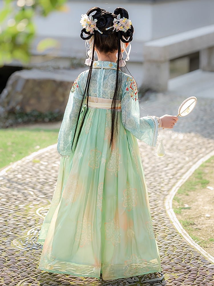 Back view of a girl wearing a green Tang dynasty princess dress outdoors