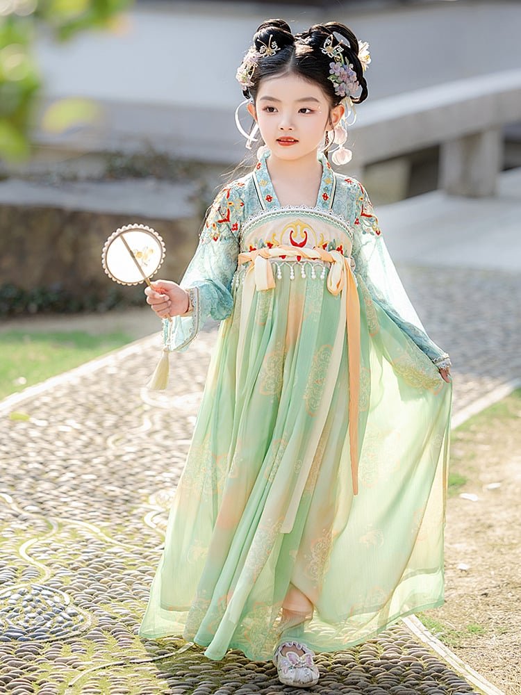 Smiling girl in a green embroidered Tang dynasty dress posing outdoors
