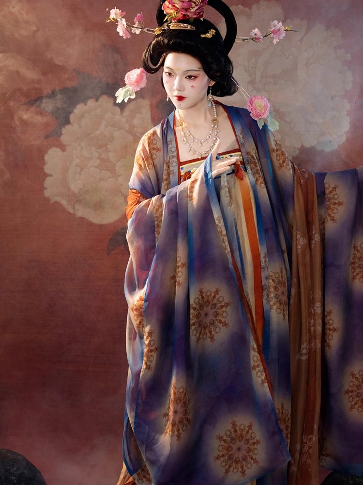 Model sitting gracefully in Tang dynasty mural hanfu with warm orange and amber tones, inspired by Dunhuang Buddhist murals.