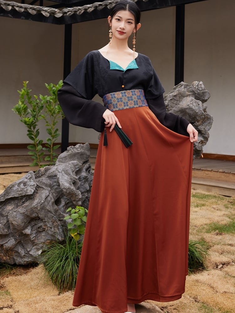 Model holding out the rust-orange hanfu skirt to show its wide flowing panels