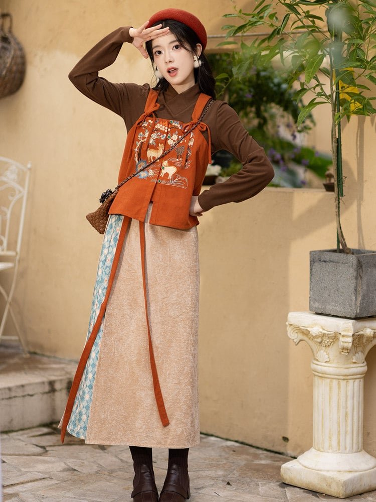 Close-up of orange embroidered vest with sheep and floral design