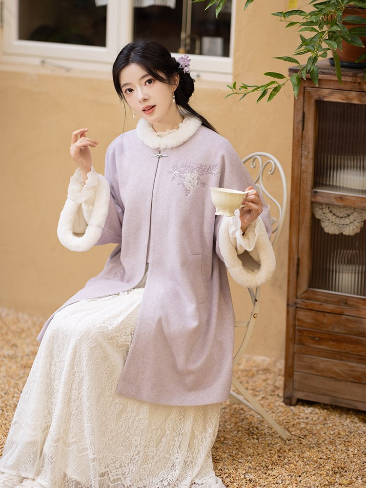 Woman sitting indoors wearing a lavender fleece-lined Hanfu coat