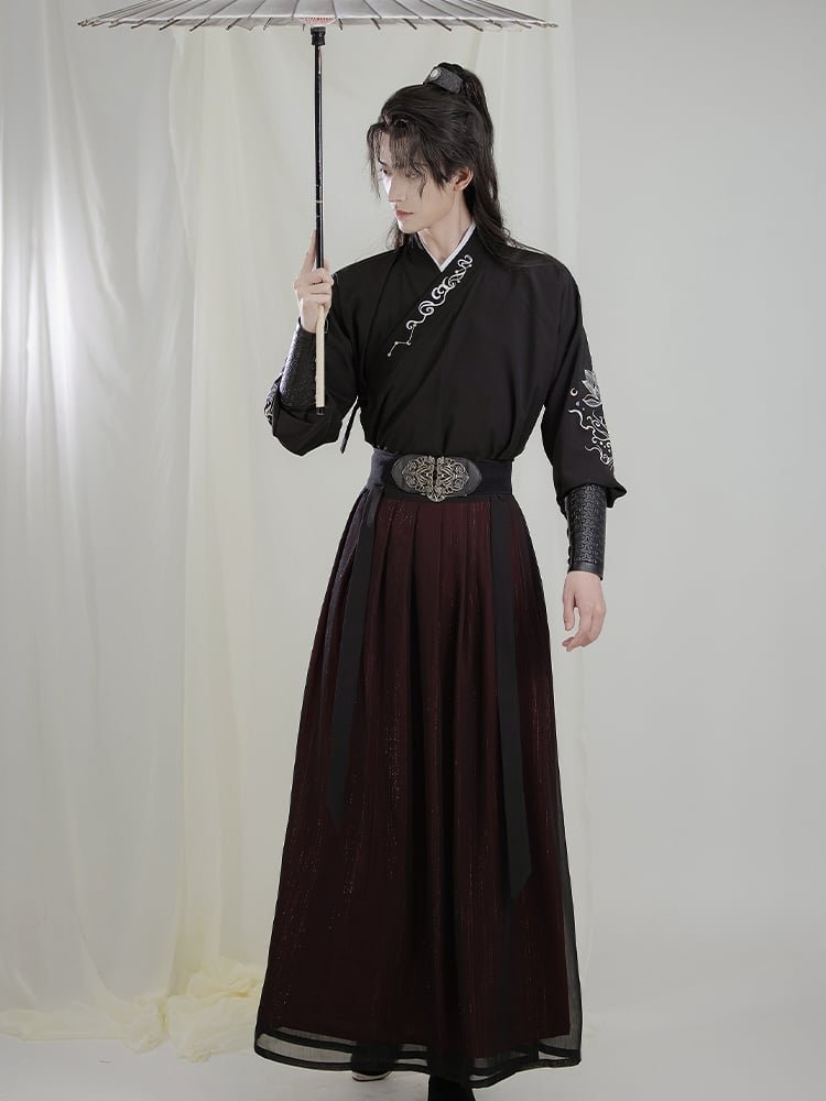 Model wearing black Wuxia Hanfu robe for men with embroidered sleeves, elegant martial arts style.