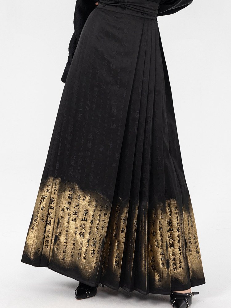 Close-up of the hem showing the shimmering gradient effect and woven gold calligraphy details of the Yan Hui embroidered skirt.