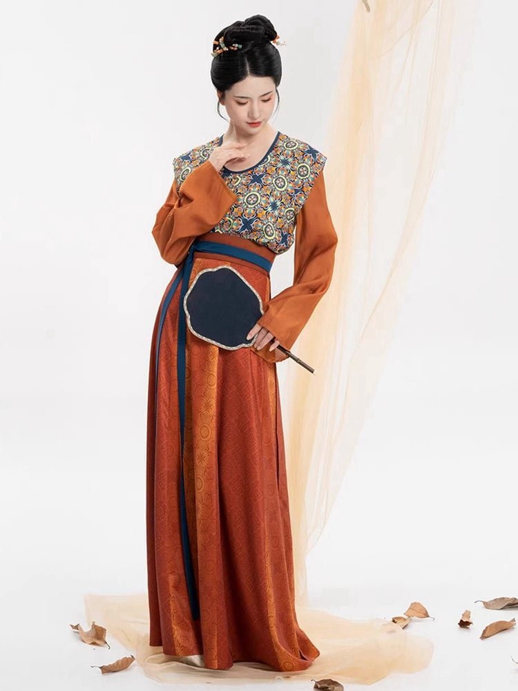 Model in Tang dynasty Hanfu cultural outfit with patterned vest and pleated skirt.