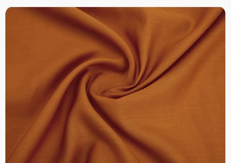 Close-up of orange Tang Hanfu fabric showing fine jacquard texture.